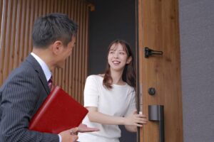 住宅会社の担当者を迎え入れる女性